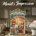 Miniature book nook display with ornate frame and Monet’s Studio banner sign