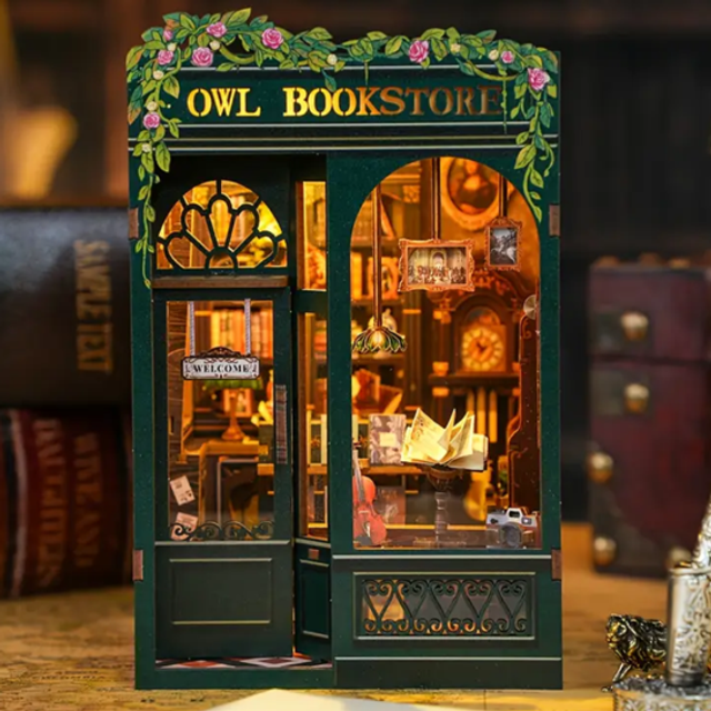 Miniature owl bookstore book nook kit with teal frame and open window display of books