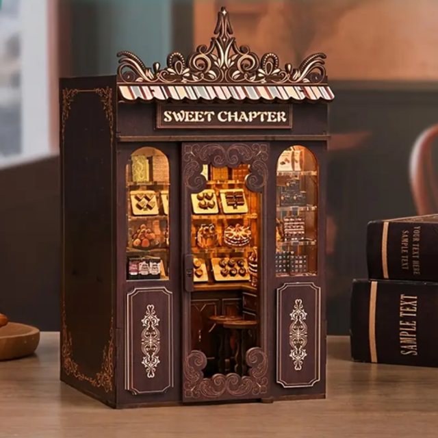 Miniature candy shop book nook kit insert with open shelves and gold “SWEET CHAPTER” sign