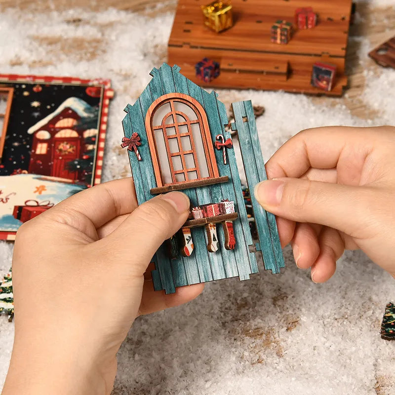 Miniature book nook window frame detail held by hands over snowy backdrop