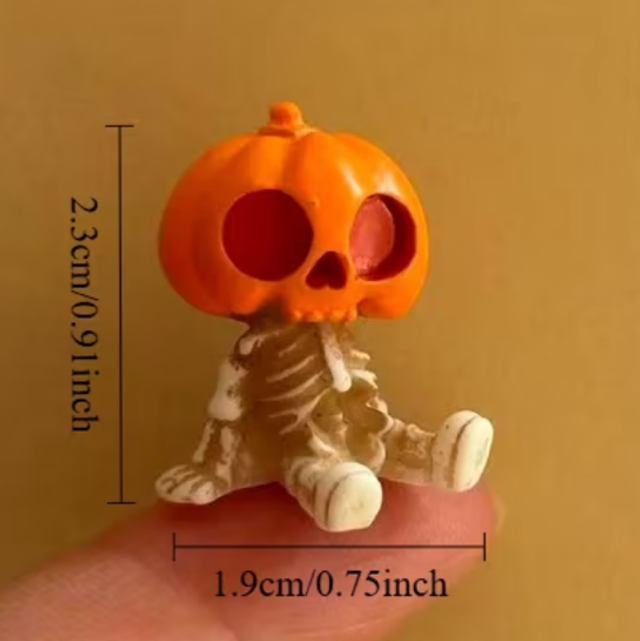 Halloween skeleton figurine with orange jack-o'-lantern head and white bones