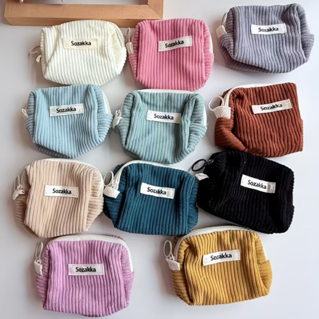 Set of zip pouches in cream, pink, striped, blue, brown, black, and mustard with Sozakka labels