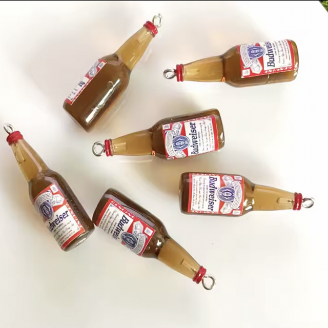 Mini booze bottles with beer labels and red caps, angled layout