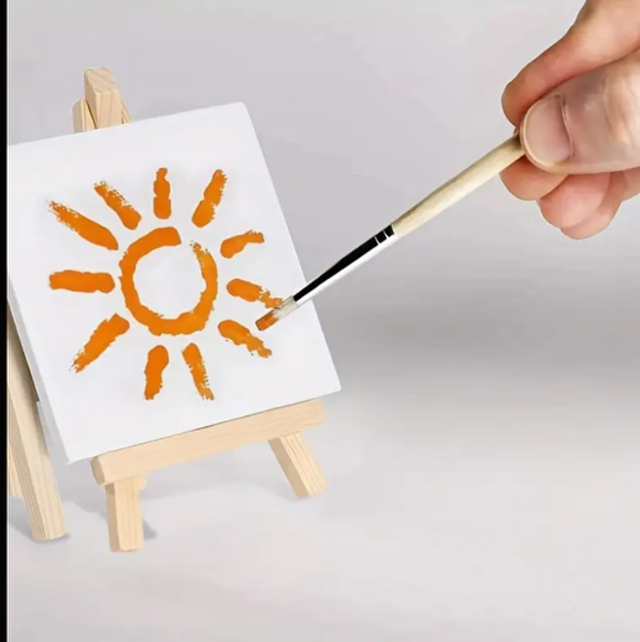 Mini canvas easel with white canvas, orange sun painting, and paintbrush