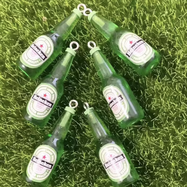 Mini booze bottles with Heineken labels, green bottles, on grass