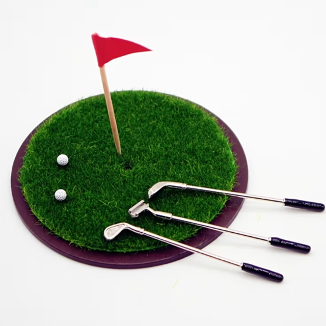 Miniature golf set with green turf, three clubs, two balls, and red flag.