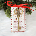 Christmas key ornament with gold key charm, red ribbon bow, on greeting tag