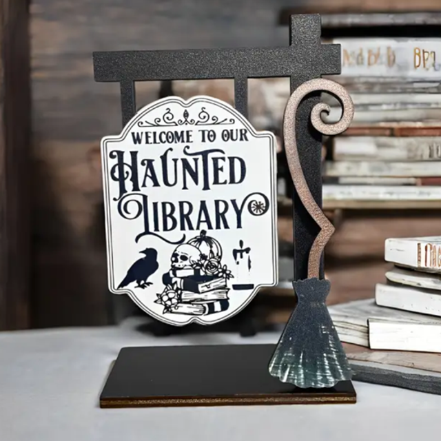 Haunted Library welcome sign with black metal stand and ornate arched design