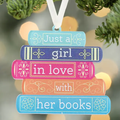 Hanging book-themed sign with stacked text (blue, pink, orange) and white ribbon