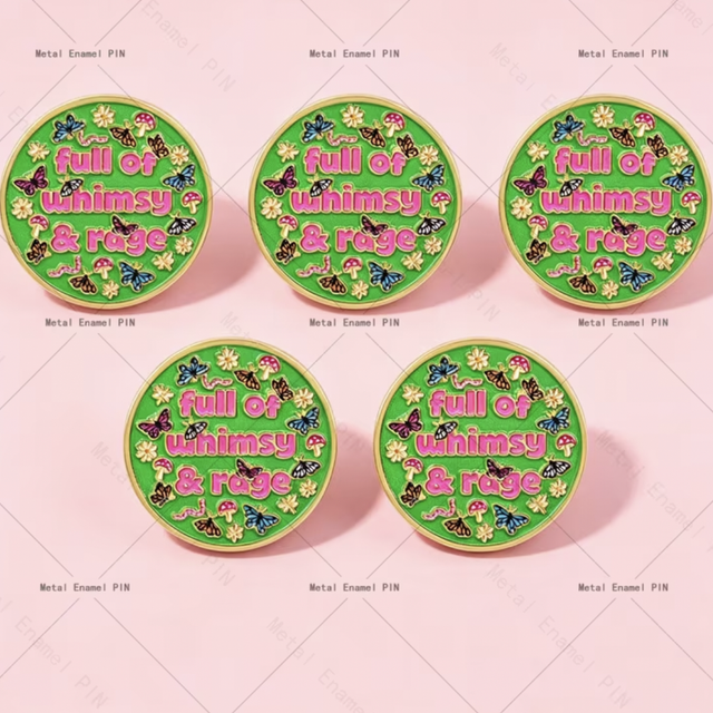Round enamel pin badge with green background and colorful "Full of whimsy & rage" text.