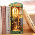 Miniature bookshelf insert with European Town facade and small printed interior scene.