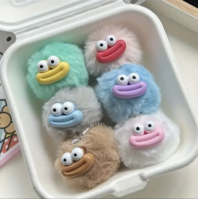 Furry face keychain charms, five cartoon plush faces in mint, blue, tan, pink.